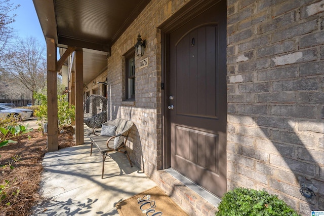entrance to property with a porch and stone siding