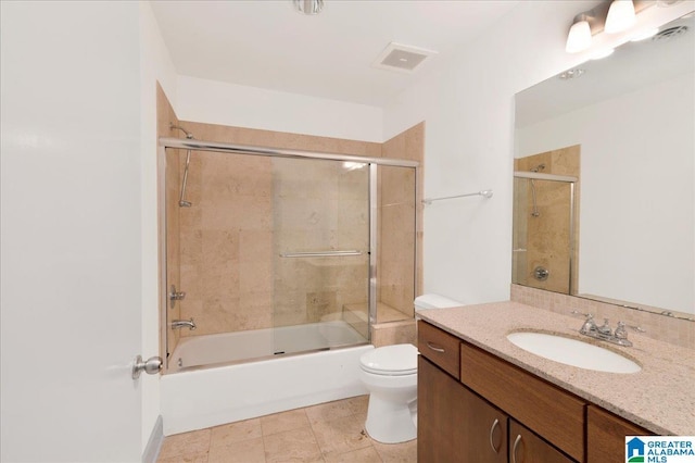 full bath with toilet, vanity, and bath / shower combo with glass door
