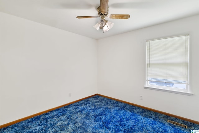 unfurnished room with dark colored carpet, baseboards, and ceiling fan