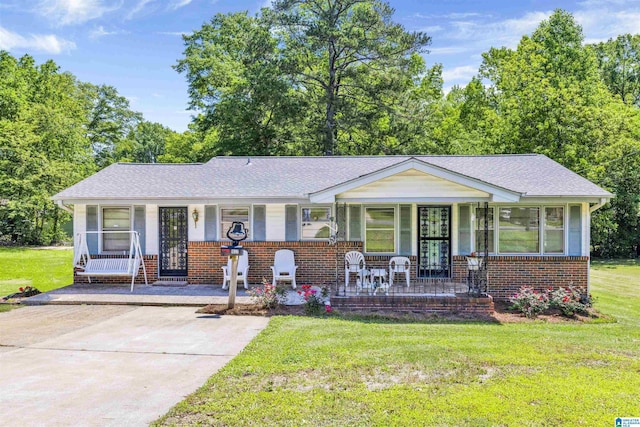 view of front of home with a porch, brick siding, and a front lawn