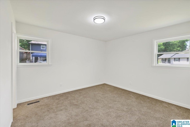 unfurnished room featuring carpet and baseboards