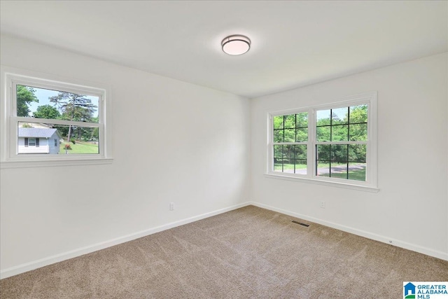 carpeted empty room with baseboards