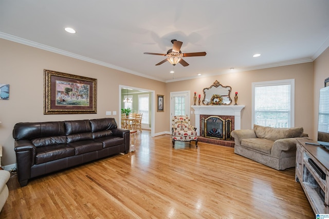 254 Macdonald Lake Rd, Springville, AL 35146 - living room featuring light wood-type flooring, ceiling fan, plenty of natural light, a brick fireplace, and crown molding