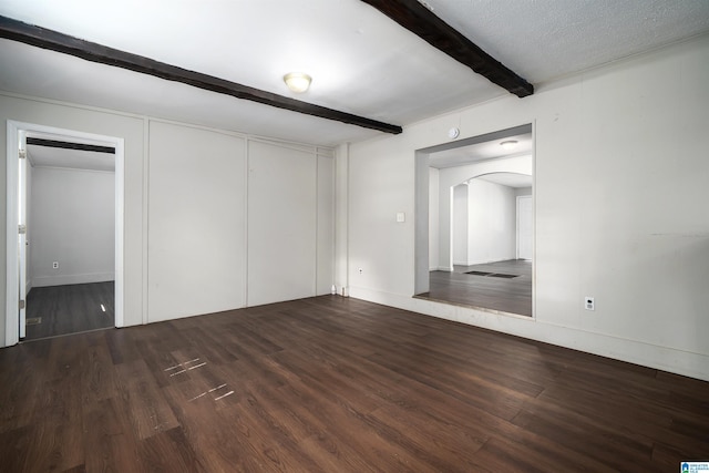 415 Thomas St, Warrior, AL 35180 - unfurnished bedroom with arched walkways, beamed ceiling, wood finished floors, a closet, and baseboards