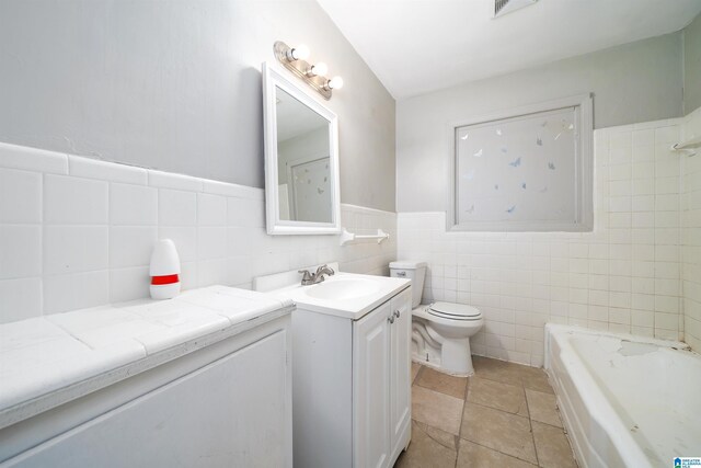 415 Thomas St, Warrior, AL 35180 - full bathroom featuring vanity, a bathtub, tile walls, toilet, and a wainscoted wall