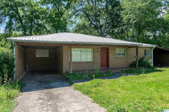 415 Thomas St, Warrior, AL 35180 - single story home featuring asphalt driveway, an attached carport, metal roof, and brick siding