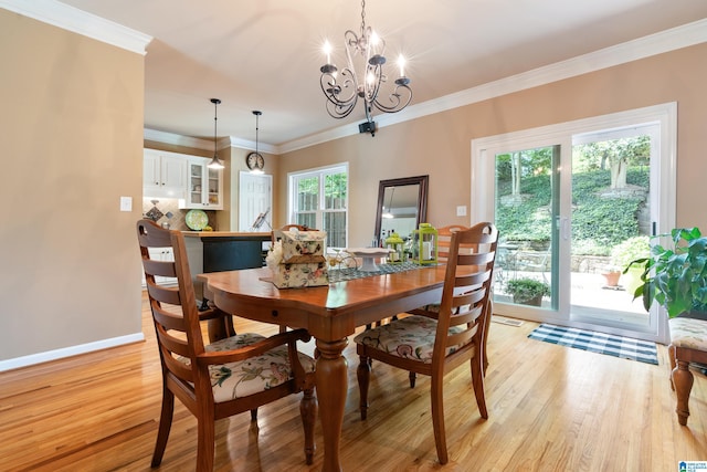 dining space featuring light wood-style floors, a chandelier, baseboards, and crown molding