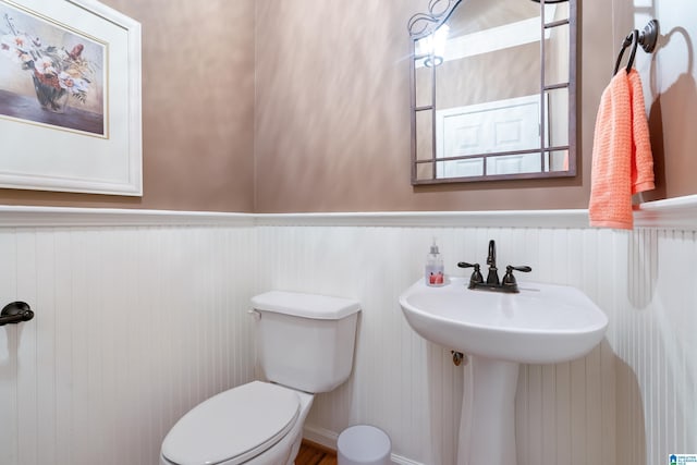 half bath with wainscoting and toilet