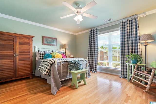 bedroom with wood finished floors, ornamental molding, baseboards, and ceiling fan
