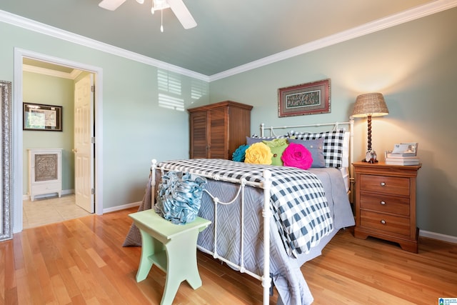 bedroom featuring crown molding, wood finished floors, baseboards, ceiling fan, and connected bathroom