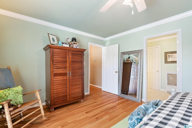 bedroom with crown molding, baseboards, light wood-style floors, and a ceiling fan