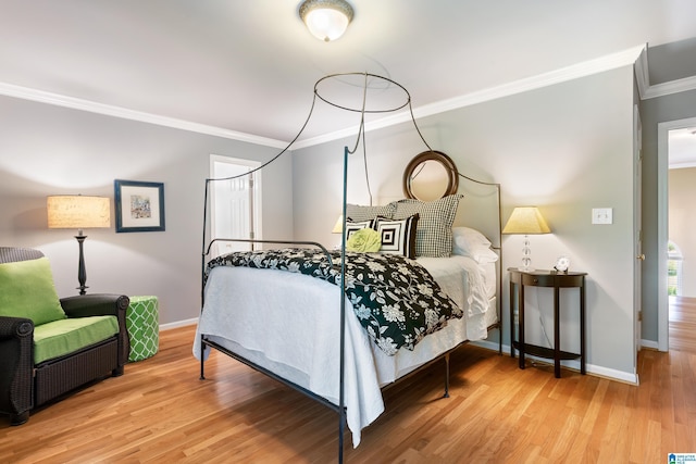 bedroom with crown molding, baseboards, and wood finished floors