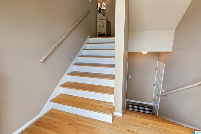 staircase featuring wood finished floors and baseboards
