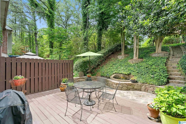 wooden terrace with outdoor dining space and fence