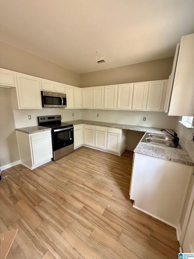7209 Pamela St, Leeds, AL 35094 - kitchen with appliances with stainless steel finishes, a sink, light wood-style flooring, and white cabinets