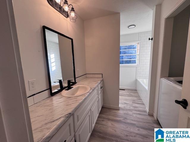 3585 County Road 26, Wadley, AL 36276 - bathroom with wood finished floors, vanity, washer / dryer, and baseboards
