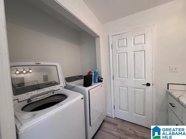3585 County Road 26, Wadley, AL 36276 - clothes washing area featuring washer and dryer and wood finished floors