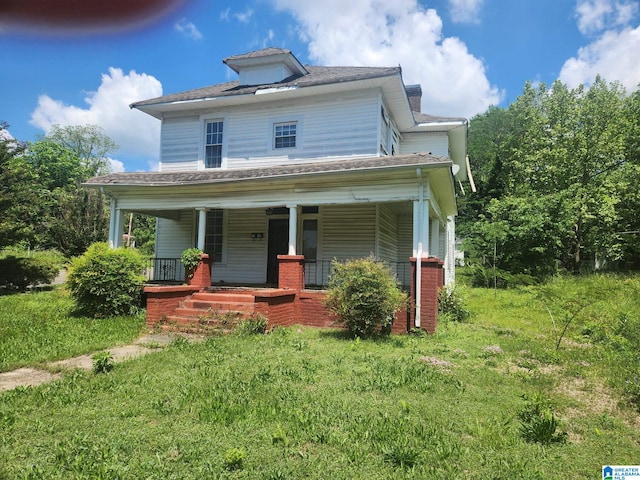 american foursquare style home featuring a porch and a chimney
