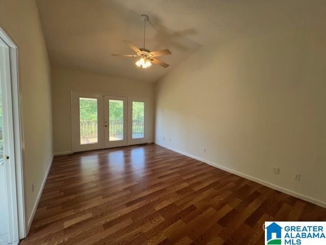 spare room with ceiling fan, dark wood finished floors, baseboards, and high vaulted ceiling