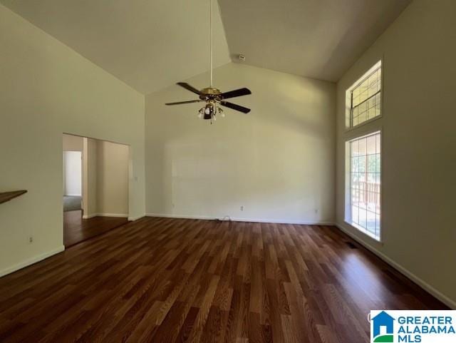 spare room with high vaulted ceiling, wood finished floors, a ceiling fan, and baseboards