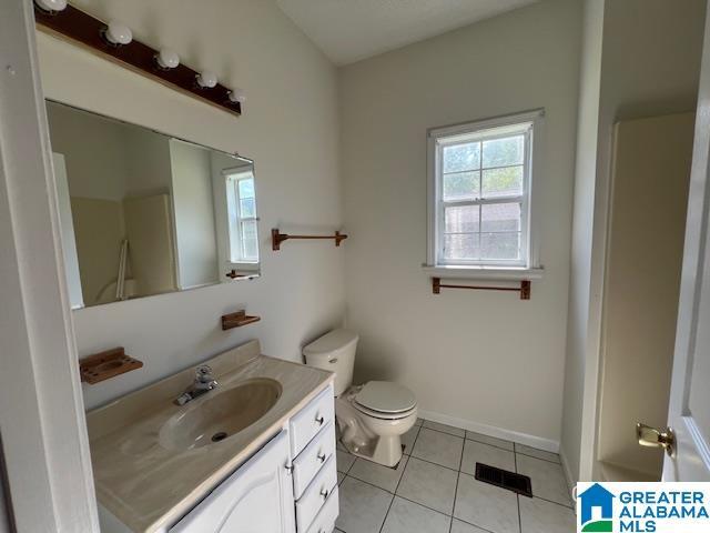 bathroom with tile patterned floors, vanity, toilet, and baseboards