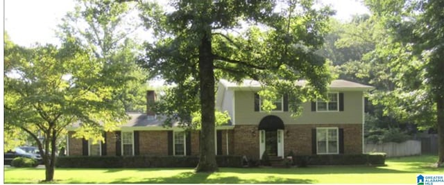 view of front facade with a front yard and brick siding