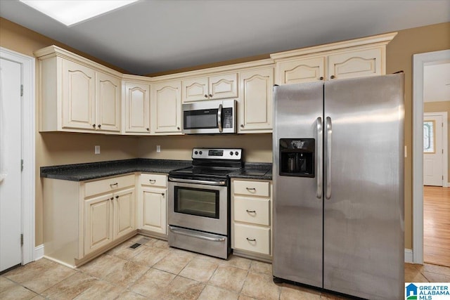 201 Hidden Meadows Dr, Hayden, AL 35079 - kitchen featuring appliances with stainless steel finishes, cream cabinets, and dark countertops