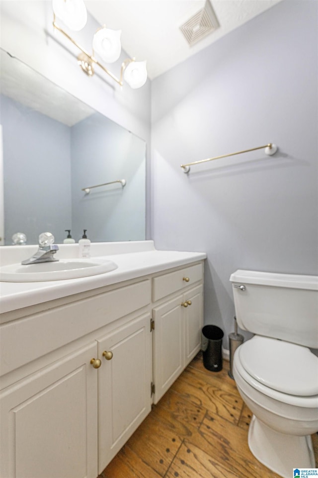 1201 Devonshire Dr NE, Jacksonville, AL 36265 - bathroom with wood finished floors, toilet, and vanity