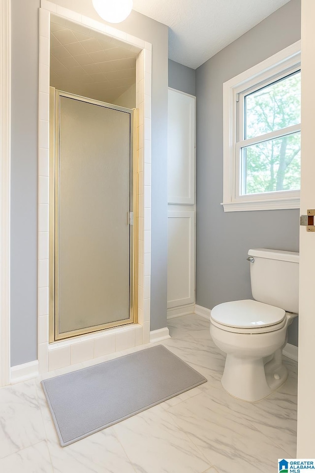 1201 Devonshire Dr NE, Jacksonville, AL 36265 - full bathroom with marble look tiles, a shower stall, toilet, and baseboards