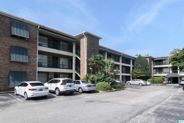 view of apartment building / complex featuring uncovered parking