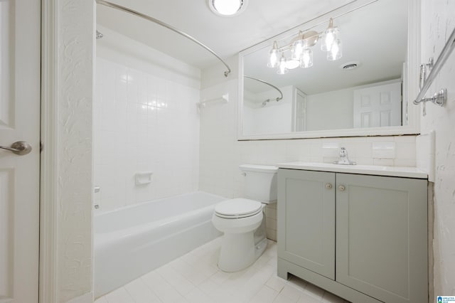 bathroom with tile patterned floors, toilet,  shower combination, vanity, and tile walls