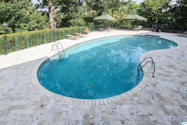 view of pool featuring fence and a patio area