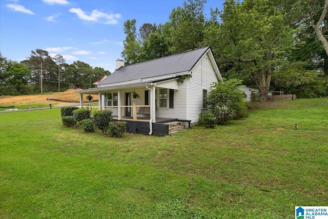 1034 Valley Rd, Oneonta, AL 35121 - back of property with covered porch, a yard, a chimney, and metal roof