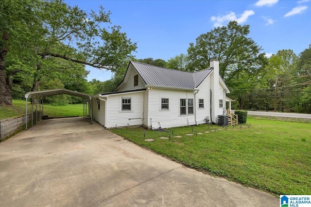 1034 Valley Rd, Oneonta, AL 35121 - view of side of home with concrete driveway, a carport, a lawn, a chimney, and metal roof