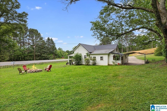 1034 Valley Rd, Oneonta, AL 35121 - view of side of home featuring a fire pit, a lawn, and metal roof