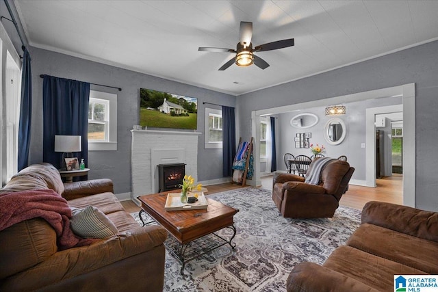 1034 Valley Rd, Oneonta, AL 35121 - living room featuring crown molding, ceiling fan, light wood finished floors, a fireplace, and baseboards