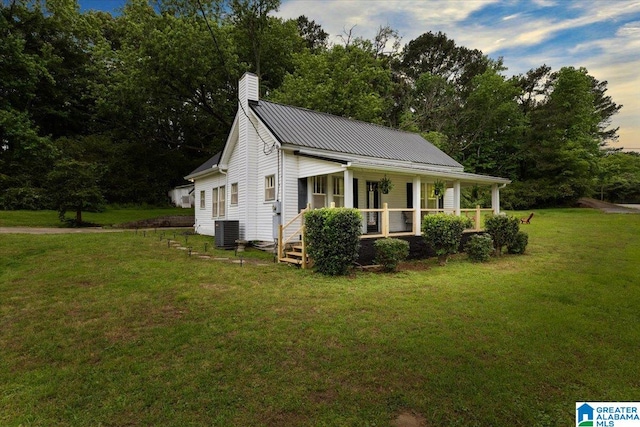 1034 Valley Rd, Oneonta, AL 35121 - view of home's exterior with cooling unit, a porch, a lawn, a chimney, and metal roof