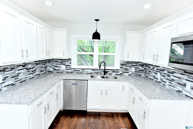 1545 32nd St, Birmingham, AL 35218 - kitchen featuring stainless steel appliances, a sink, dark wood-style floors, white cabinetry, and decorative backsplash