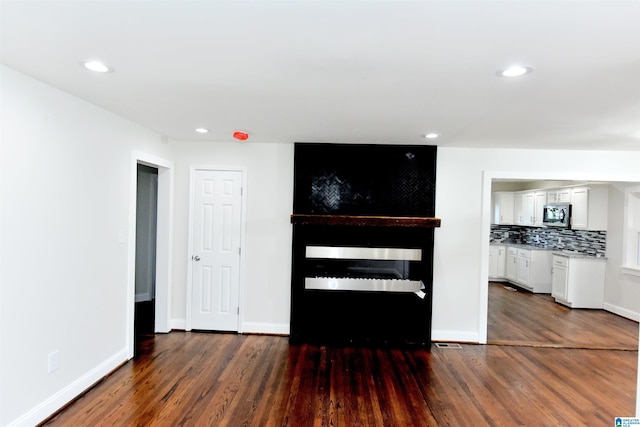 1545 32nd St, Birmingham, AL 35218 - unfurnished living room with dark wood-style flooring, recessed lighting, and baseboards