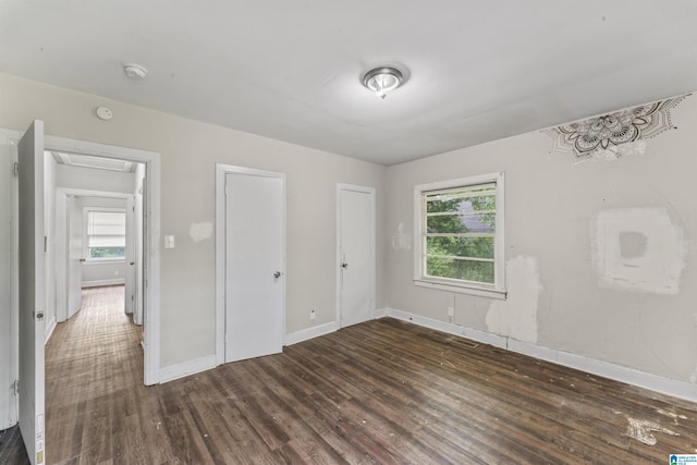 unfurnished bedroom featuring dark wood-type flooring and baseboards