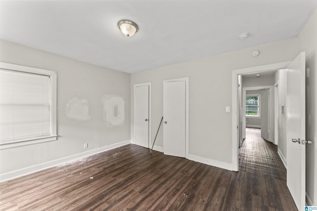 unfurnished bedroom featuring wood finished floors and baseboards