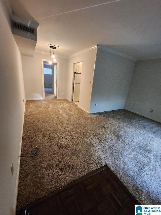 empty room with carpet floors, ornamental molding, and baseboards