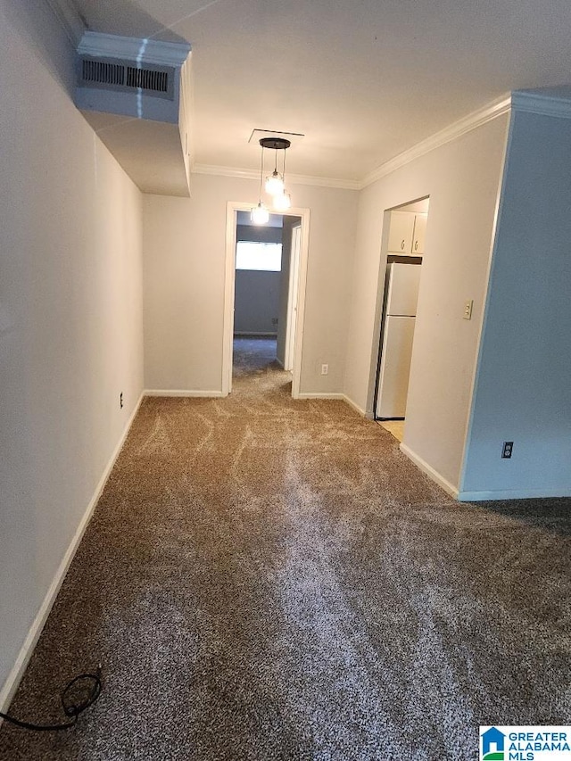 carpeted spare room featuring crown molding and baseboards