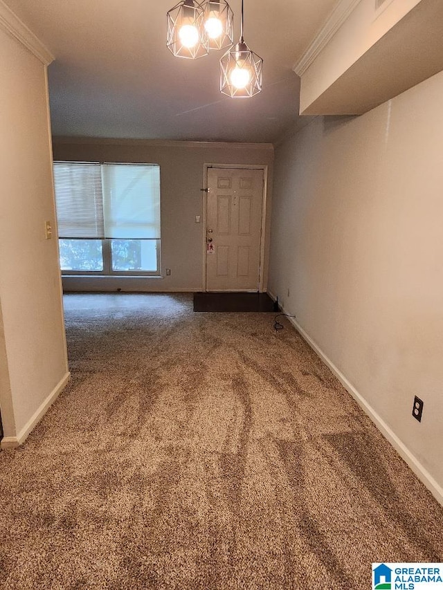 carpeted foyer with ornamental molding and baseboards