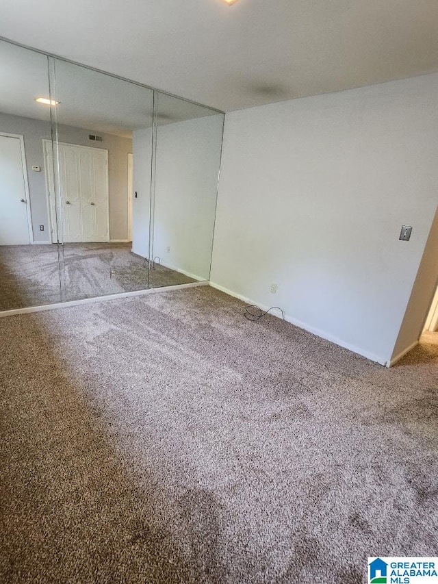 unfurnished bedroom with carpet floors, baseboards, and a closet