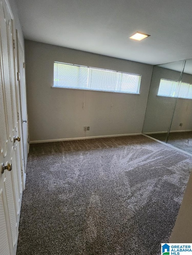 unfurnished bedroom with carpet flooring and baseboards