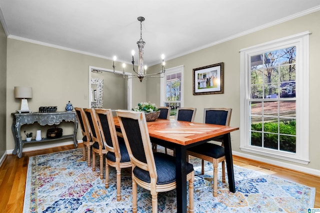 2673 Buckboard Rd, Birmingham, AL 35244 - dining room featuring a chandelier, ornamental molding, wood finished floors, and baseboards