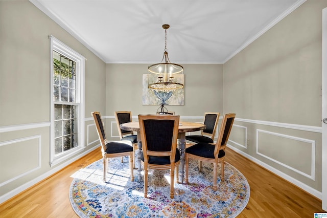 2673 Buckboard Rd, Birmingham, AL 35244 - dining area featuring light wood finished floors, crown molding, a chandelier, a decorative wall, and a wainscoted wall