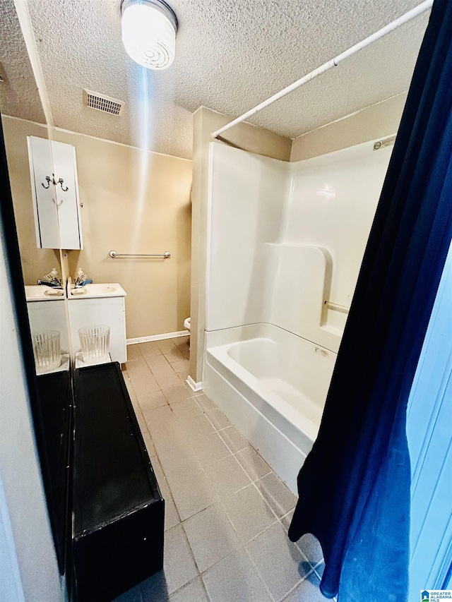 1 Annie Humber Rd, Adger, AL 35006 - bathroom featuring tile patterned floors, a textured ceiling, toilet, vanity, and bathing tub / shower combination