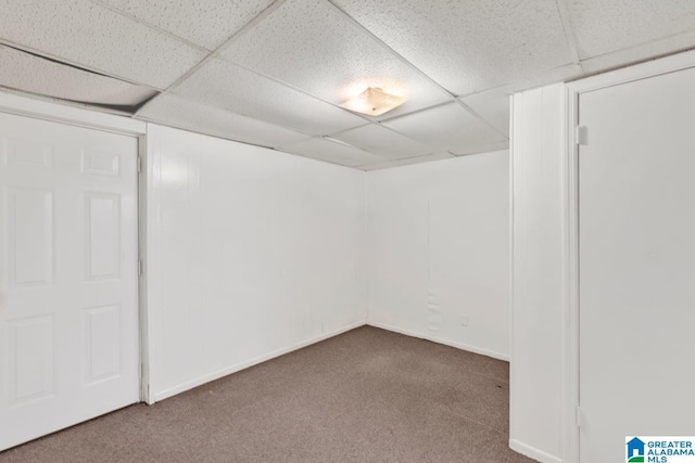 finished below grade area featuring carpet, a drop ceiling, and baseboards